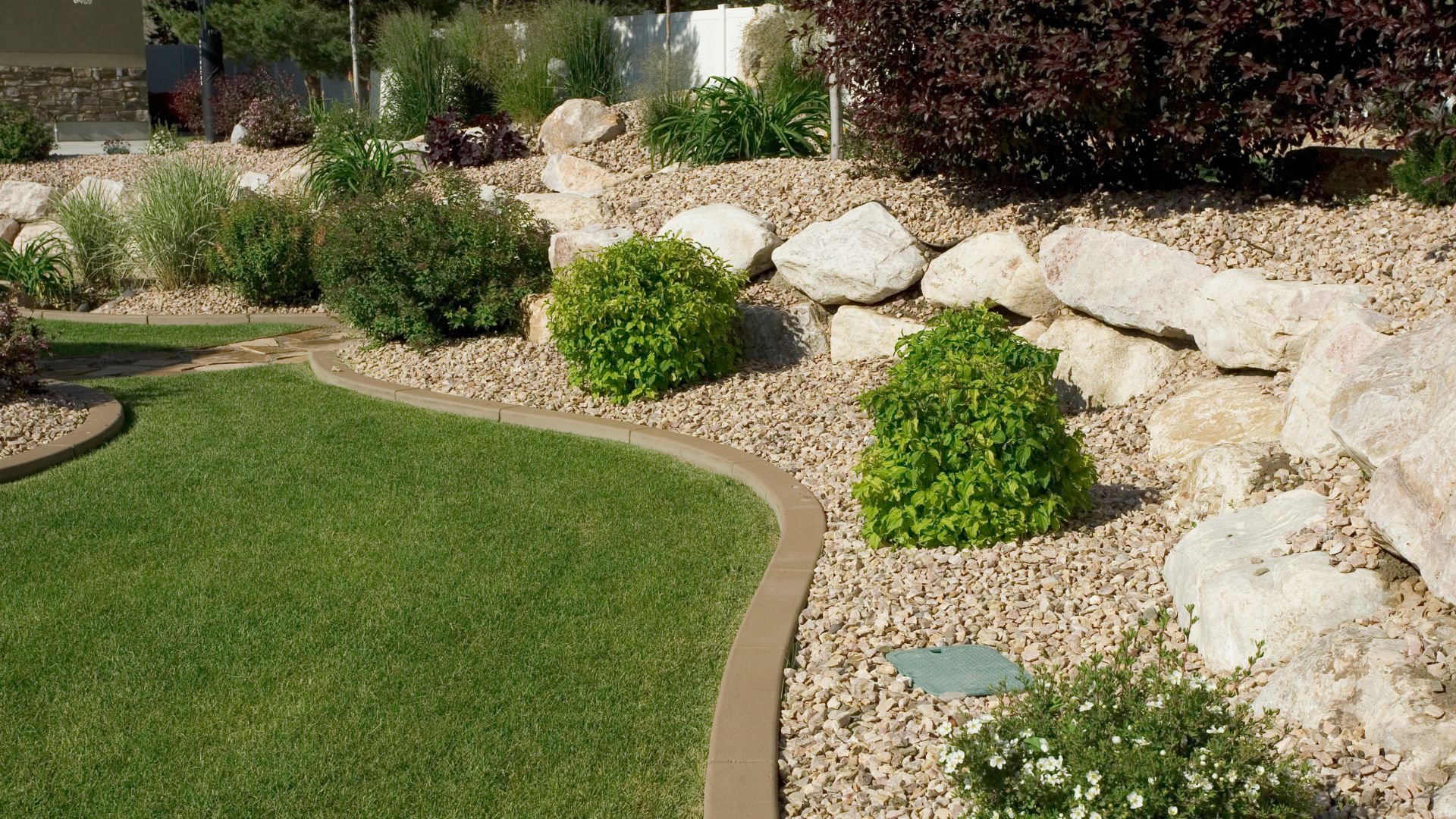 A beautifully manicured garden designed by Neotecture, featuring lush lawns and vibrant flower beds.